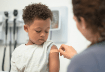 Nurse giving boy a bandaid. COVID-19 vaccine. Des Moines Mom
