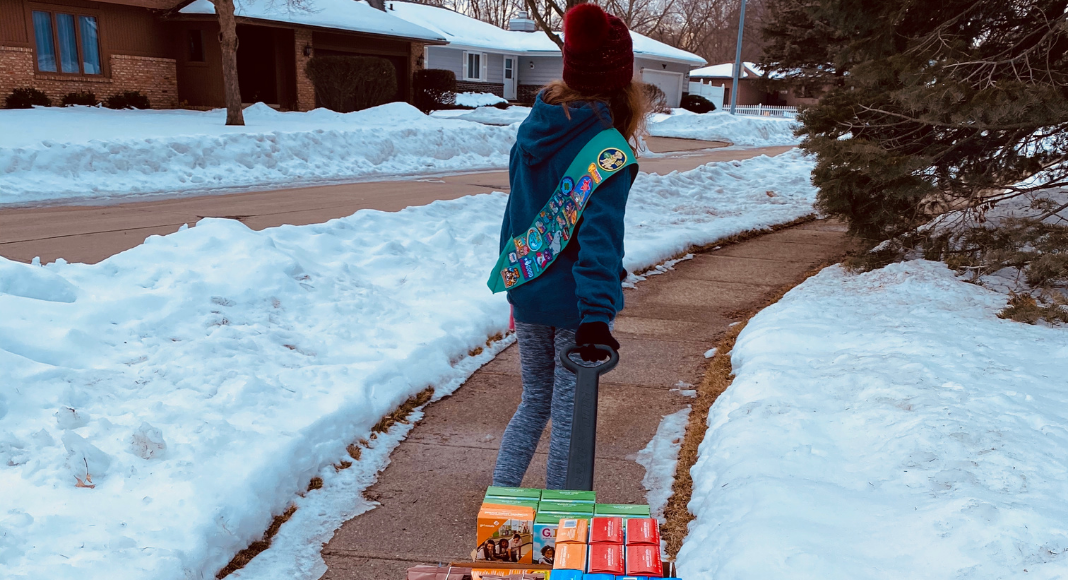 girl scout walking down sidewalk with cookies. Des Moines Mom