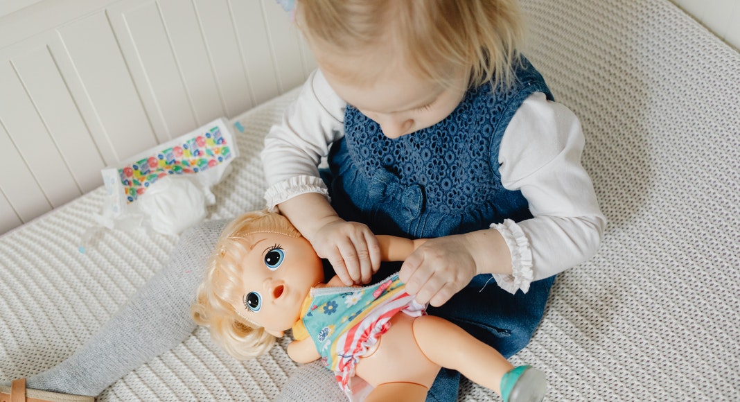 toddler girl playing with baby doll. GirlMom. Des Moines Mom
