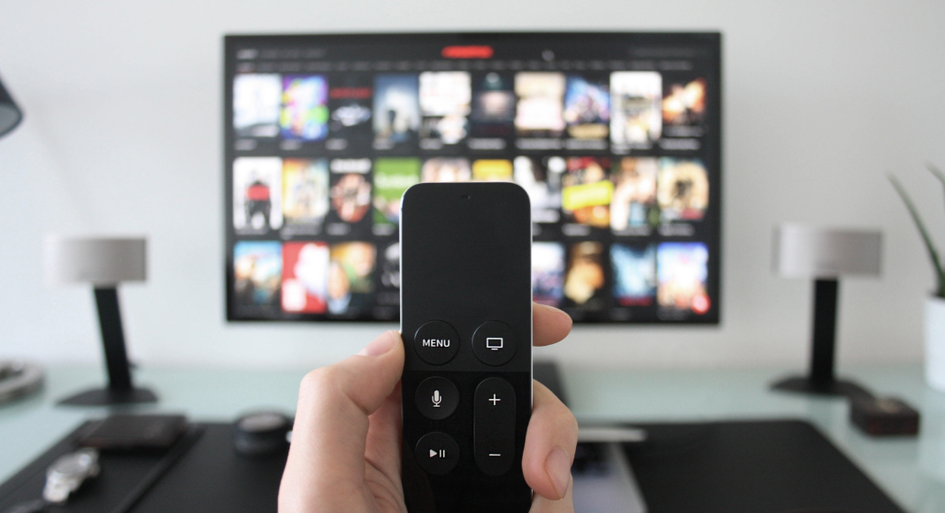 hand holding apple tv remote. 101 shows to binge right now