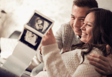 man and woman looking at ultrasound pictures. traumatic pregnancy. Des Moines Mom