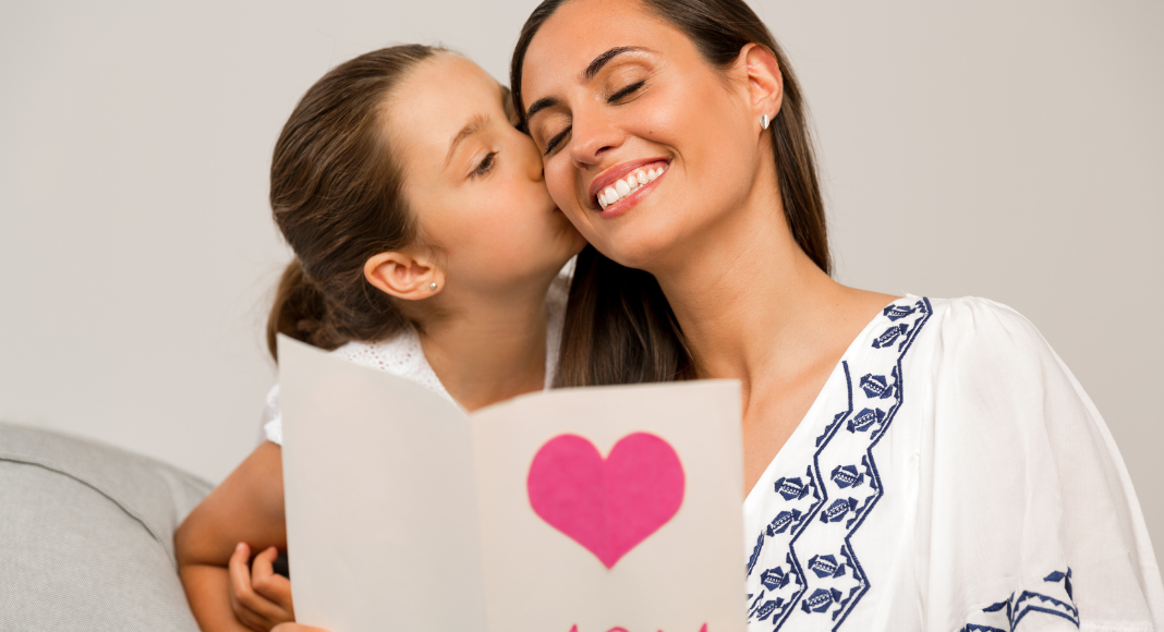 girl kissing mom's cheek and heart card 
