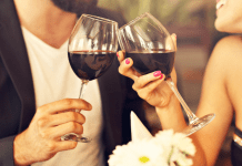 Couple toasting with wine glasses. date night restaurants in Des Moines. Des Moines Mom