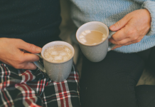 couple holding mugs with hot cocoa. winter date ideas