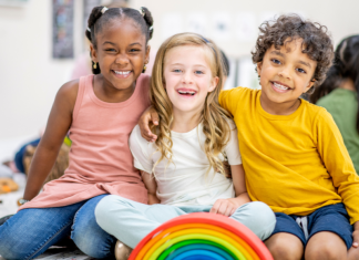 kids smiling with a rainbow toy