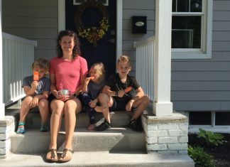 kids and woman sitting on front steps of home